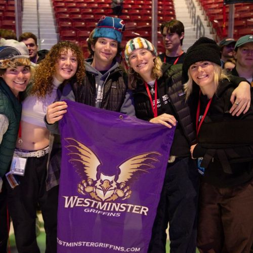 4 ski and snowboard team students holding up a Westminster Griffins banner