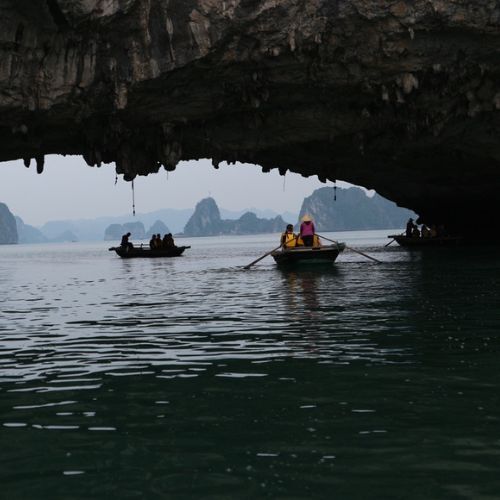 2 boats with people floating on a river