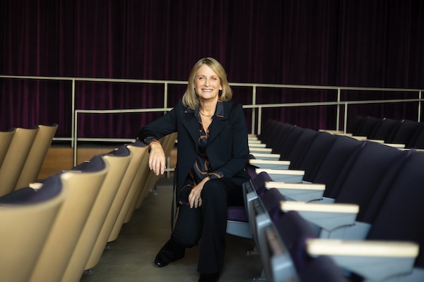 president beth dobkin seated in a row of auditorium chairs