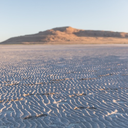 Rippled sandy plain with a low hill in the distance