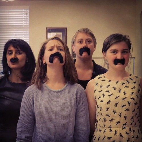 four girls/women with fake mustaches