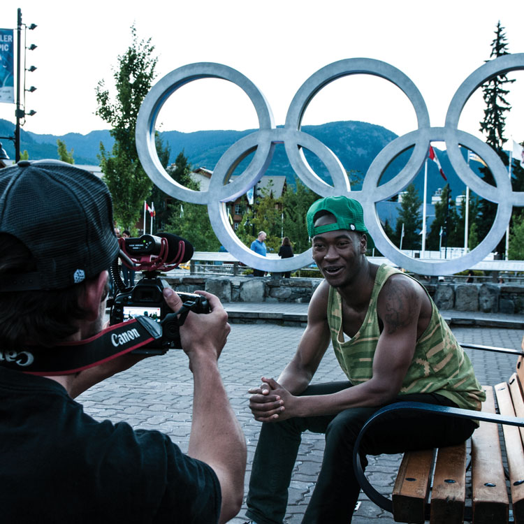 man in front of Olympic rings