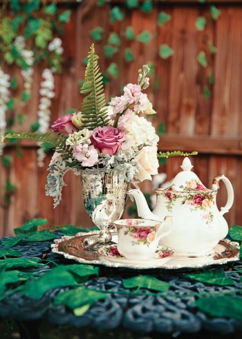 Teapot and kettle with flower arrangements on silver tray