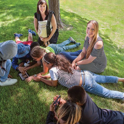 students sitting on grass
