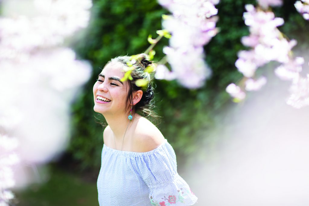 Marley Dominguez smiling surrounded by pink flowers