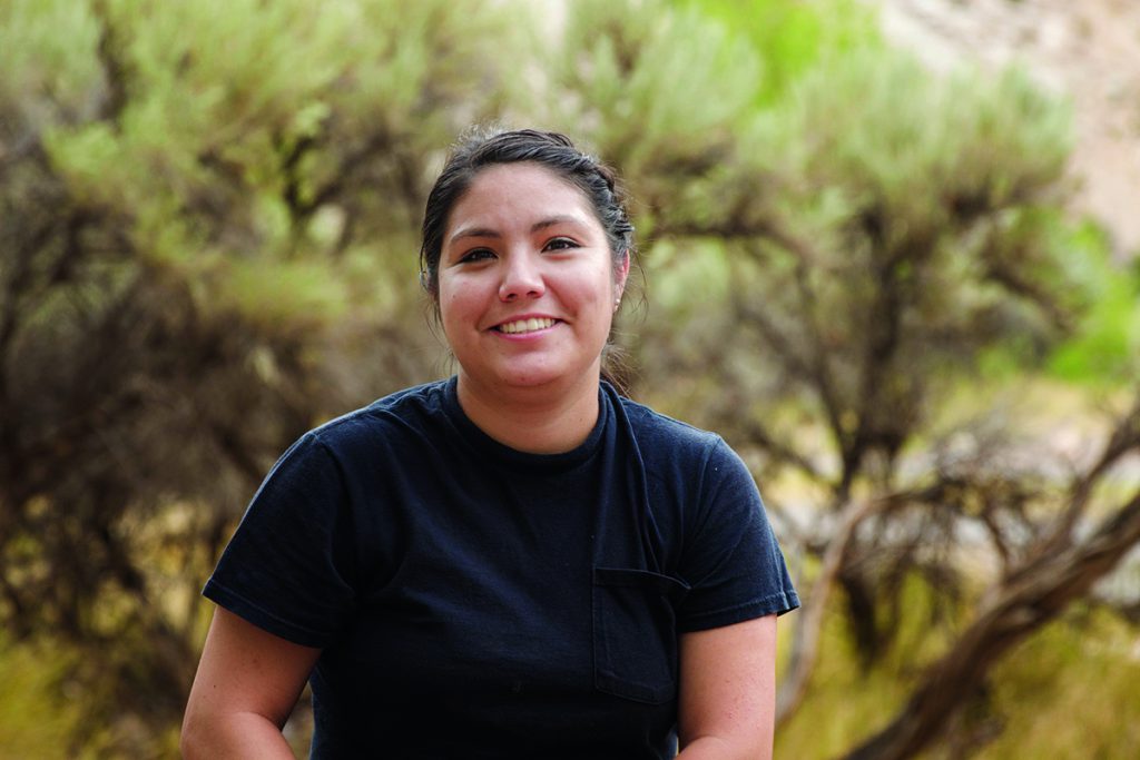 student in front of trees