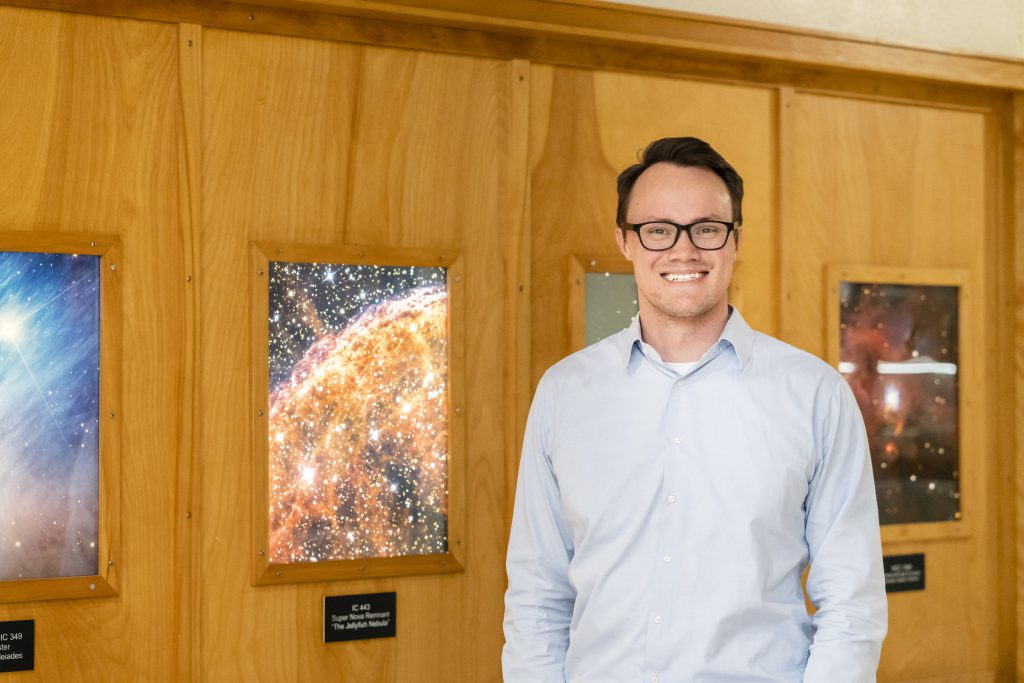 Benjamin Rackham in front of space poster