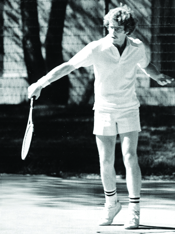 black and white photo of male tennis player on the court