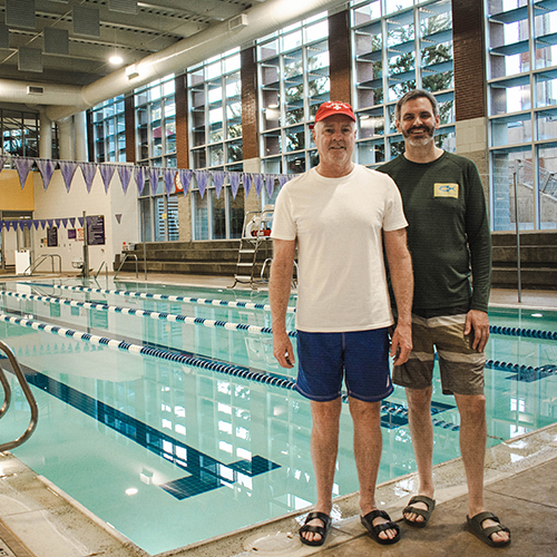 Patrick Curtin and his partner, Aaron Flood pose in front of pool in HWAC