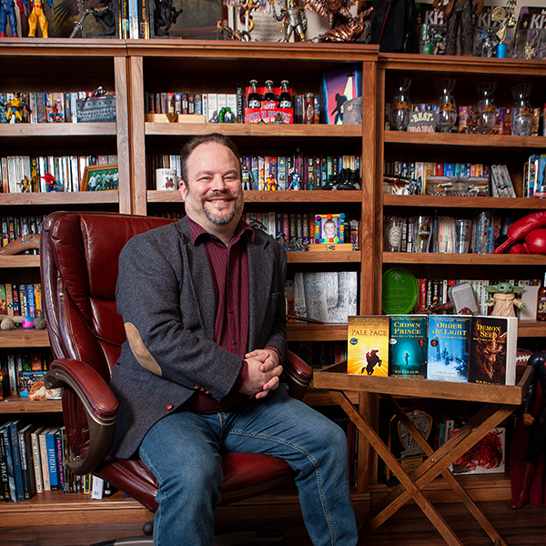 Bill Killpack sitting in library surrounded by books