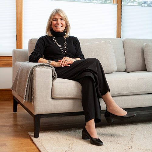 woman sitting on a grey sofa