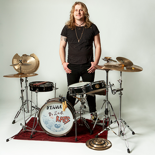 a person standing behind a drumset