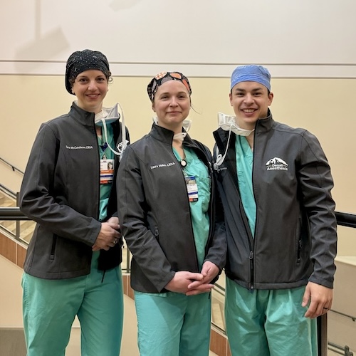 three nurses in green scrubs standing together